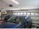 A well lit garage with a red golf cart and blue car parked inside at 13675 Sw 111Th Ave, Dunnellon, FL 34432