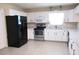 Spacious kitchen with black refrigerator, white cabinets and stainless-steel appliances at 13675 Sw 111Th Ave, Dunnellon, FL 34432