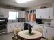 Bright, functional kitchen with white cabinets, modern appliances, and a round dining table at 13675 Sw 111Th Ave, Dunnellon, FL 34432