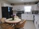 Well-lit kitchen featuring white cabinets, modern appliances, and a cozy dining area at 13675 Sw 111Th Ave, Dunnellon, FL 34432
