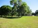 Expansive grassy lawn with mature trees and landscaping, perfect for outdoor activities at 13675 Sw 111Th Ave, Dunnellon, FL 34432