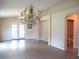 Spacious living room with wood floors, chandelier, and access to a bathroom and french doors at 13675 Sw 111Th Ave, Dunnellon, FL 34432