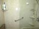Shower featuring adjustable shower head, safety bar, and shelving at 13675 Sw 111Th Ave, Dunnellon, FL 34432