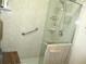 Walk-in shower featuring adjustable shower head, safety bar, and shelving at 13675 Sw 111Th Ave, Dunnellon, FL 34432