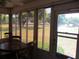 Bright sunroom featuring a ceiling fan and large windows with views of the lush green lawn and landscaping at 13675 Sw 111Th Ave, Dunnellon, FL 34432