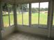 Tiled sunroom with a view of a tree-lined backyard and adjacent homes at 13675 Sw 111Th Ave, Dunnellon, FL 34432