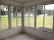 Enclosed tiled sunroom with views of the serene and expansive grassy backyard at 13675 Sw 111Th Ave, Dunnellon, FL 34432