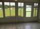 Tiled sunroom with windows to enjoy the view of a lush green backyard at 13675 Sw 111Th Ave, Dunnellon, FL 34432
