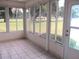 Enclosed sunroom with tile flooring and scenic views of the landscaped outdoors at 13675 Sw 111Th Ave, Dunnellon, FL 34432