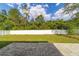 Large backyard with a gray brick patio, white fence, and plenty of green space and trees at 14085 Sw 34Th Terrace Rd, Ocala, FL 34473