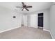 Bedroom featuring neutral gray walls, carpet, ceiling fan, closet, and access to a bathroom via a white door at 14085 Sw 34Th Terrace Rd, Ocala, FL 34473
