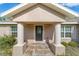 Inviting front entrance with decorative glass door, stone tile landing and columned porch at 14085 Sw 34Th Terrace Rd, Ocala, FL 34473