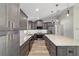 Updated kitchen featuring gray cabinets, stainless steel appliances, marble backsplash, and a spacious center island at 14085 Sw 34Th Terrace Rd, Ocala, FL 34473