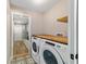 Laundry room featuring a modern washer and dryer, butcher block countertop, and patterned tile flooring at 14085 Sw 34Th Terrace Rd, Ocala, FL 34473