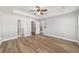 Spacious main bedroom with wood-look floors, ceiling fan, and doorways to bathroom, closet and laundry at 14085 Sw 34Th Terrace Rd, Ocala, FL 34473