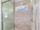 Walk-in shower featuring glass door, tile surround, tiled shower floor, and a convenient shampoo niche at 14085 Sw 34Th Terrace Rd, Ocala, FL 34473