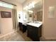 Bright bathroom featuring double vanity with a large mirror and tile flooring at 19059 Sw 92Nd Loop, Dunnellon, FL 34432