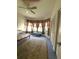 This bedroom features a bay window with curtains, ceiling fan, and closet space at 19059 Sw 92Nd Loop, Dunnellon, FL 34432