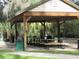 Covered picnic pavilion with tables, trash cans and manicured landscaping at 19059 Sw 92Nd Loop, Dunnellon, FL 34432