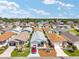 An aerial view shows well-maintained homes with landscaped yards and driveways in a vibrant neighborhood under a blue sky at 2693 Craven Way, The Villages, FL 32162