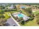 An aerial photograph captures a community pool with clear blue water, palm trees, and a surrounding parking area at 2693 Craven Way, The Villages, FL 32162