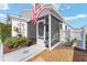 Charming home featuring a landscaped yard, an American flag, and a cozy screened-in porch at 2693 Craven Way, The Villages, FL 32162