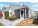 Charming home featuring a landscaped yard, an American flag, and a cozy screened-in porch at 2693 Craven Way, The Villages, FL 32162