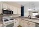 This kitchen features stainless steel appliances, neutral countertops, and white cabinets at 2693 Craven Way, The Villages, FL 32162