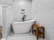 Bright bathroom with a freestanding tub, rainfall shower head, and modern white tiling at 2780 Ne 127Th Pl, Anthony, FL 32617