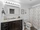 Well-lit bathroom features a dark vanity and a framed mirror at 2780 Ne 127Th Pl, Anthony, FL 32617