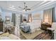 Airy main bedroom featuring tray ceilings, French doors to a private patio, and light blue walls at 2780 Ne 127Th Pl, Anthony, FL 32617