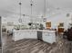 Bright kitchen featuring a large island with stone countertops, wood floors, and an open layout at 2780 Ne 127Th Pl, Anthony, FL 32617
