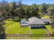 Aerial view of property with a screened pool, spacious backyard, and surrounded by mature trees at 3230 Se 45Th St, Ocala, FL 34480