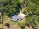 Birds eye view of a home with screened pool surrounded by a wooded lot and lush lawn at 3230 Se 45Th St, Ocala, FL 34480