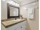 Bathroom with granite countertop, decorative framed mirror, and cream-colored tile at 3230 Se 45Th St, Ocala, FL 34480