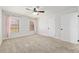 Carpeted bedroom with ceiling fan, two windows with pink curtains, and white trim at 3230 Se 45Th St, Ocala, FL 34480