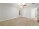 Carpeted bedroom with a ceiling fan, white trim, and a bright window at 3230 Se 45Th St, Ocala, FL 34480