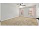This bedroom features neutral carpeting, a ceiling fan and two windows with pink curtains at 3230 Se 45Th St, Ocala, FL 34480