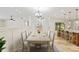 Bright dining room features a long table, chandelier lighting, and seamless access to kitchen and breakfast bar at 3230 Se 45Th St, Ocala, FL 34480