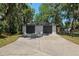Detached two-car garage with dark gray doors and large driveway at 3230 Se 45Th St, Ocala, FL 34480