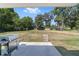 Outdoor patio with a grill overlooks a spacious backyard with mature trees and a partial fence-line at 3810 Sw 5Th Ave, Ocala, FL 34471