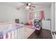 Bright bedroom featuring a ceiling fan and a comfortable crib with a playful design at 3810 Sw 5Th Ave, Ocala, FL 34471