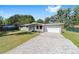 Charming gray brick home featuring a well-manicured lawn, tidy landscaping and a bright-colored front door at 3810 Sw 5Th Ave, Ocala, FL 34471