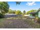 A spacious backyard features a lush lawn, framed by mature trees and a charming privacy fence at 3834 Se 9Th Pl, Ocala, FL 34471