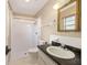 Bathroom with white shower, toilet and vanity sink with dark countertop and mirror at 3834 Se 9Th Pl, Ocala, FL 34471