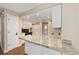 Well-lit kitchen with granite countertops, an eat-in bar and white cabinets at 3834 Se 9Th Pl, Ocala, FL 34471