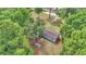 Aerial view showcasing a cozy home surrounded by lush trees, with a charming fire pit area at 4180 W Anthony Rd, Ocala, FL 34475