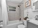 Bright bathroom with a shower-tub combination, light gray tiling, and stylish fixtures at 4180 W Anthony Rd, Ocala, FL 34475