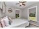 Bright bedroom with a ceiling fan, two windows, and comfortable bedding for a relaxing stay at 4180 W Anthony Rd, Ocala, FL 34475