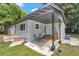 Exterior view of home with covered patio, seating, and fresh light gray paint at 4180 W Anthony Rd, Ocala, FL 34475